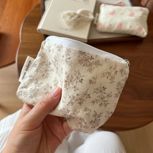 Detail of floral cotton mini pouch with zipper and simple wish label on wooden table