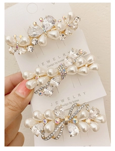Macro view of crystal butterfly hair clip with high-luster pearls on gold alloy base
