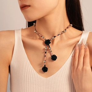 Gros plan de roses en résine noire et collier en cuir léopard rose sur mannequin