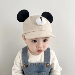 Close-up of beige baby sun hat with cute black cartoon ears and white 3D nose detail