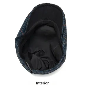 Detail view of the soft black cotton lining and fine stitching inside the plaid newsboy cap