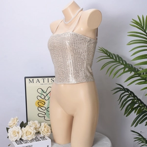 Detail of champagne sequin crop top with back straps and shimmery finish