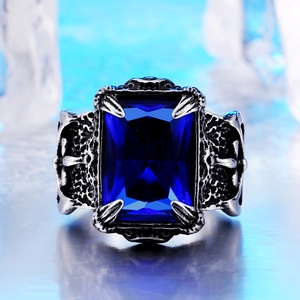 Macro detail of men's vintage steel ring with blue gemstone and eagle claw setting