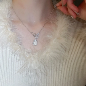 Detail of silver gourd necklace with zircon edges and white cat eye stone on neck
