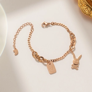 Elegant rose gold titanium bracelet with rabbit charm and engraved pendant on beige base
