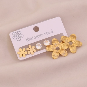 Detailed view of three pairs of gold stainless steel stud earrings with flower designs