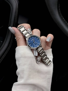 Detail showing Scottie quartz watch with silver steel band and blue dial in car interior