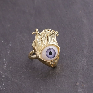 Macro view of anatomical heart-shaped ring in 18K gold with purple eye detail