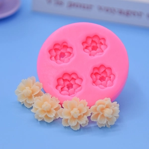 Macro view of 4-cavity floral silicone mold with detailed beige fondant flower samples