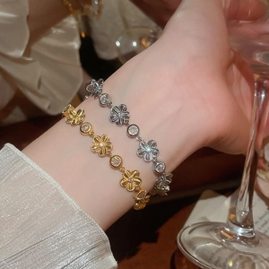 Détail de bracelets fleurs en or et argent avec zircon et texture en métal brossé