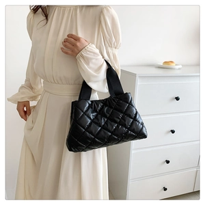 Détail du sac cabas matelassé en nylon noir avec de larges bretelles en tissu doux