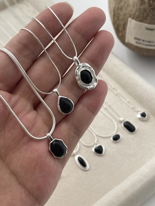 Close-up of S925 silver necklaces with black agate in heart and water drop shapes