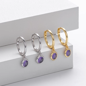 Detail view of S925 sterling silver hoop earrings with purple round gemstone pendants