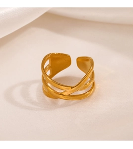Detail of gold multilayer crisscross open ring on elegant white silk background fabric