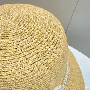 Detailed macro view of woven paper straw texture and elegant pearl trim on summer sun hat