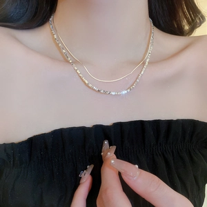Close-up of double-layered silver crushed stone necklace on model showing layered style