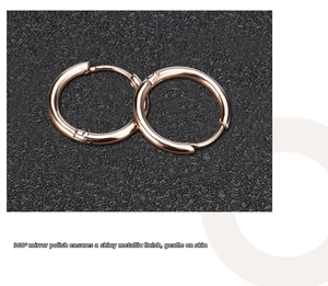 Macro shot of rose gold hoop earrings with a polished mirror finish on leather