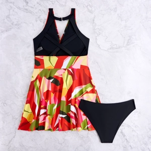 Detail of floral printed tankini top with cross-back straps and black bikini bottoms