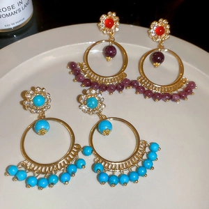 Detailed macro view of Bohemian style tassel earrings with turquoise and burgundy beads