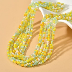 Macro shot of 3mm colorful faceted rondelle beads in yellow and mint green