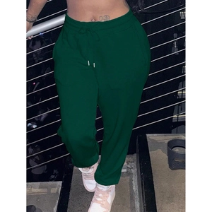 Detail view of dark green jogger pants featuring a functional white drawstring and elastic waist