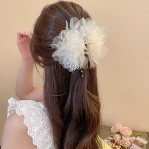Detail of white mesh flower hair claw clip with pearls on a half-up hairstyle
