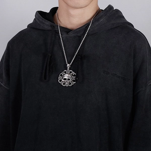 Detail of silver vintage skull pendant necklace worn by a model on a twisted chain