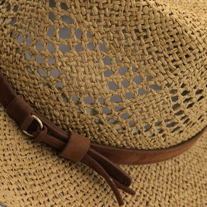 Détail du tressage en raphia ajouré et ruban en daim marron avec boucle métallique