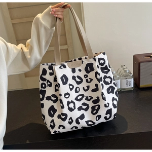 Détail du sac cabas en toile léopard avec anses kaki et étiquette en cuir Boons