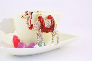 Detailed close-up of a crystal-studded golden camel keychain with red enamel and rhinestones