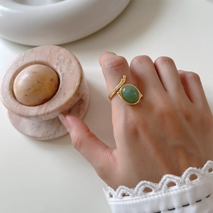 Close-up of a 925 sterling silver gold-plated ring featuring an oval green jade gemstone