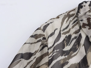 Detail of V-neck chiffon dress showing brown tiger print fabric texture and semi-sheer material