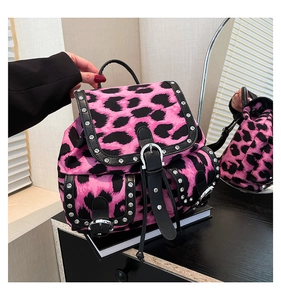 Detailed view of pink leopard print backpack with silver metal studs and belt buckle