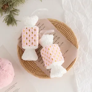 Pink and white candy-shaped Christmas tree ornaments in a cozy rustic woven basket