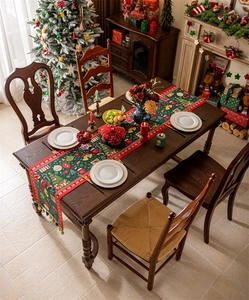 Christmas table runner with Santa motifs and tassels on a wooden dining table