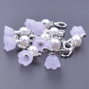 Detail of purple frosted resin flowers and faux pearl angel wing pendants for gifts
