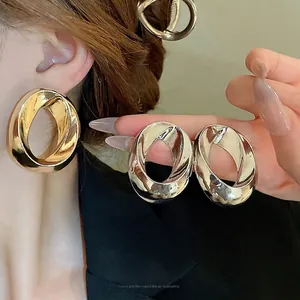 Minimalist geometric twisted hoop earrings in polished gold and silver finishes