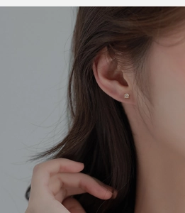 Close-up of model wearing square-cut 18K gold-plated cubic zirconia stud earrings