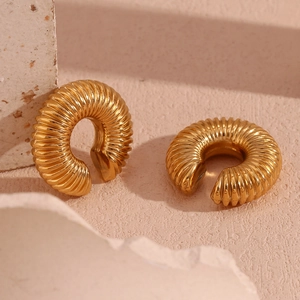 Detailed macro view of 18K gold-plated stainless steel hoop earring with spiral texture