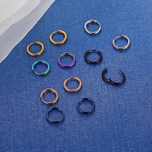 Multiple colorful stainless steel hoop earrings showcased on a blue textured background