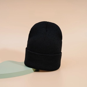 Gros plan sur la texture en tricot côtelé d'un bonnet d'hiver classique noir