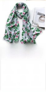 Detail of soft voile scarf featuring green four-leaf clover and pink heart floral print