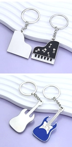 Détail des porte-clés guitare et piano en émail avec des strass brillants et polis