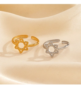 Detail of gold and silver hexagram open rings on soft beige satin fabric background