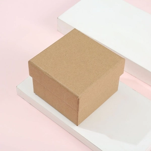 Minimalist square brown kraft paper jewelry gift box with lid on a modern pink background
