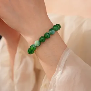Elegant green beaded bracelet with translucent round stones on a silk fabric background
