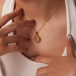 Detail of 18k gold plated sun and moon necklace with sparkling crystals on a model