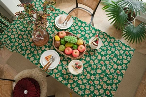 Detailed festive scene of green cotton linen tablecloth with Christmas gingerbread patterns