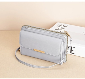 Detail view of a light grey multifunctional phone purse with gold hardware accents