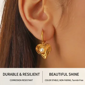 Detail of vintage irregular heart gold-plated earring with a single white pearl for women